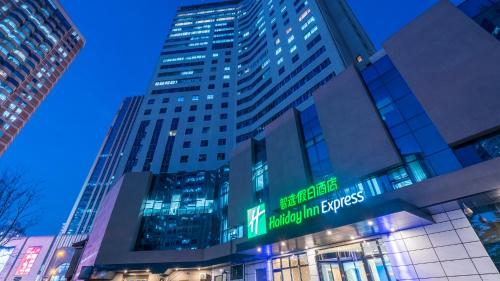 a tall building with a sign in front of it at Holiday Inn Express Qingdao City Center by IHG in Qingdao