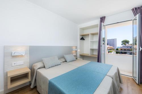 een slaapkamer met een bed en een groot raam bij Apartament Massanet 2b in Canyamel