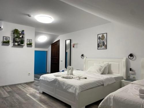 Pensiunea Belvedere Murighiol في موريغيول: غرفة نوم بسريرين بيض في غرفة