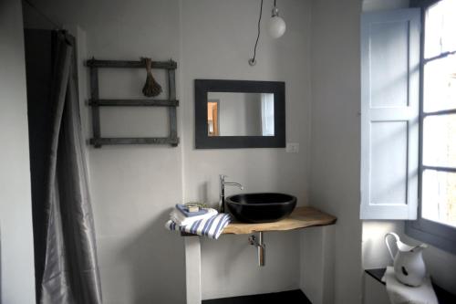 baño con lavabo negro y espejo en B&B Ududemà, en Dolcedo