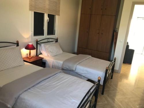 um quarto de hotel com duas camas e um candeeiro sobre uma mesa em Relaxing rural retreat in mainland Greece em Ermioni