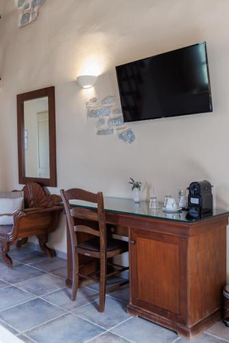a room with a desk with a television on the wall at Castello Antico Hotel in Gythio