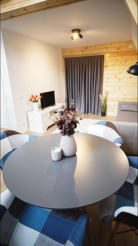a white table with a vase of flowers on it at Cabanele A Frame, Salciua Noua in Sălciua Nouă