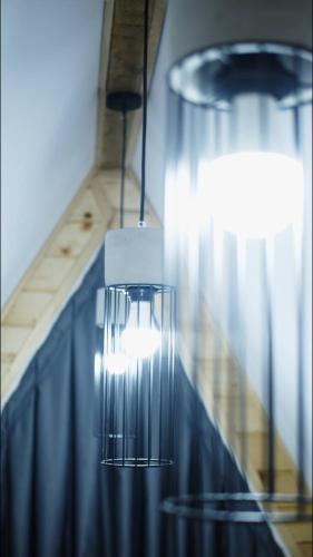 a chandelier hanging over a table with a blue curtain at Cabanele A Frame, Salciua Noua in Sălciua Nouă