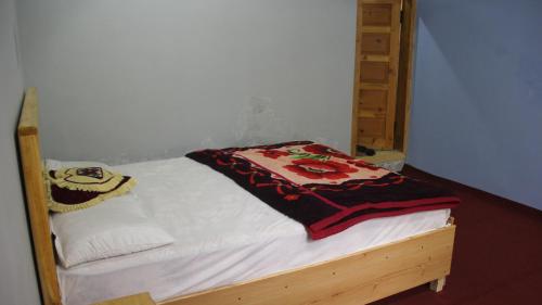 a small bed with a blanket on top of it at Rakaposhi Amin Hotel & Restaurant Pissan Hunza Nagar Gilgit Baltistan in Gilgit