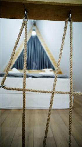 a rope swing with a bed in the background at Cabanele A Frame, Salciua Noua in Sălciua Nouă