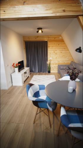a living room with a table and blue chairs at Cabanele A Frame, Salciua Noua in Sălciua Nouă