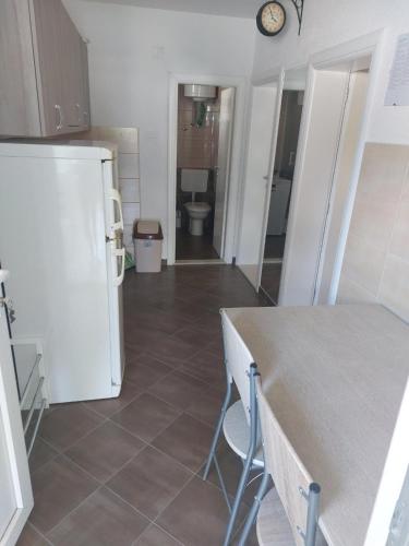 a kitchen with a white refrigerator and a tile floor at Apartments & rooms Leon in Neum