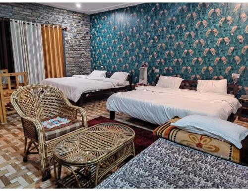 - une chambre avec deux lits, une chaise et un mur dans l'établissement Hotel Sunnyside Palace, Almora, à Almora