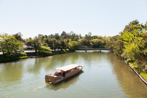 a boat on a river with people in it at Matsue Excel Hotel Tokyu in Matsue