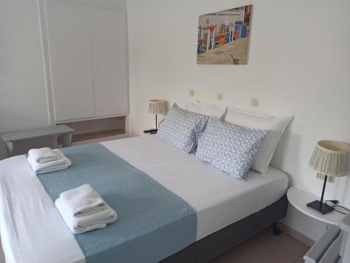 a white bedroom with a bed with towels on it at Villa Mertiza in Myrtos