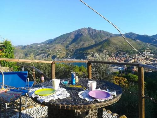 a table on a balcony with a view of the mountains at B&B Maremesco in Levanto