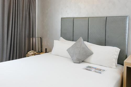a bedroom with a white bed with white pillows at Regency Grand Suites in Manila