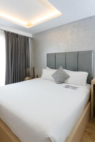 a large white bed in a room with a window at Regency Grand Suites in Manila