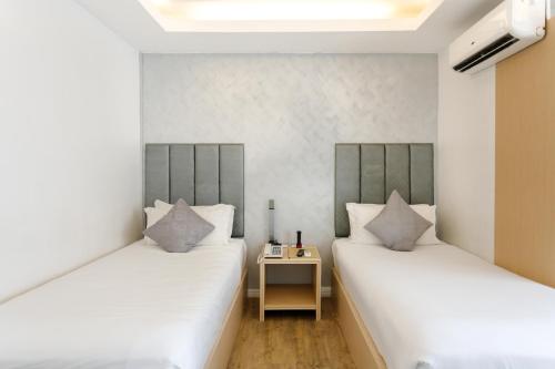 dwa łóżka w pokoju ze stolikiem w obiekcie Regency Grand Suites w mieście Manila