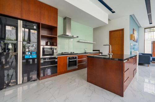 a large kitchen with wooden cabinets and a counter top at Perfect Son Tra Beach Villa Da Nang with sea view in Da Nang