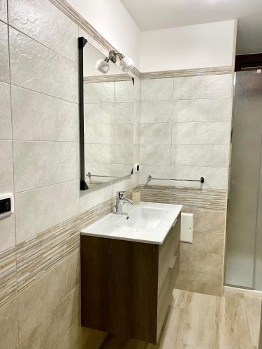 a bathroom with a sink and a mirror at Appartamento Salentorelax in Salve