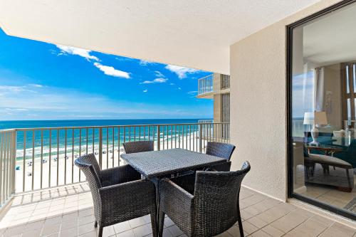 ein Tisch und Stühle auf einem Balkon mit Blick auf das Meer in der Unterkunft Shoalwater 804 in Orange Beach