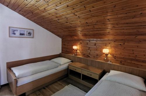 - 2 lits dans une chambre dotée de murs en bois dans l'établissement Apartments Steger Sand in Taufers Campo Tures, à Sand in Taufers