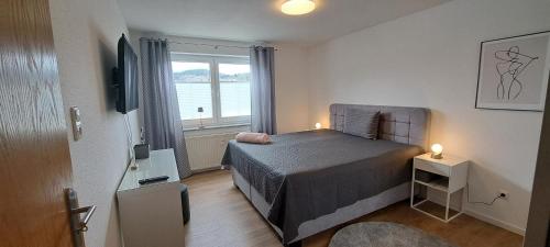 um pequeno quarto com uma cama e uma janela em Ferienwohnungen Sachsenblick em Grafenau