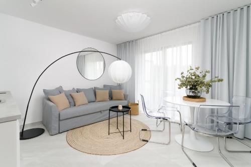 a living room with a couch and a table at Apartamenty Lambert Grzybowo in Grzybowo