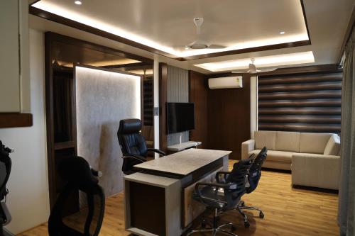 戈爾哈布爾的住宿－Blisss Hotel Kolhapur，客厅配有沙发和桌椅
