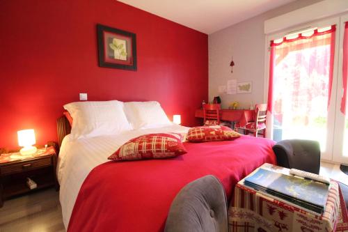 1 dormitorio con paredes rojas y 1 cama con 2 almohadas en L'Eden de Floridylle en Xonrupt-Longemer