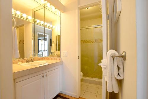 a white bathroom with a sink and a shower at Kauhale Makai 506 in Kihei