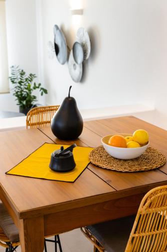 a wooden table with a bowl of fruit on it at Mirabilia, Unique view meets true elegance in Krotiri