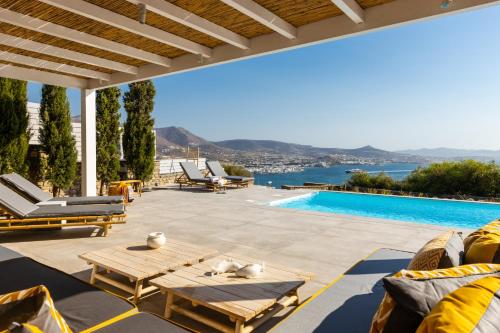 a patio with a table and chairs and a swimming pool at Mirabilia, Unique view meets true elegance in Krotiri