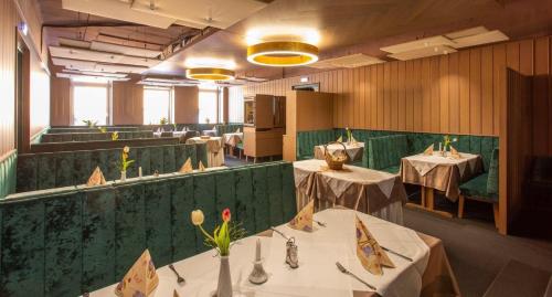 un restaurante con mesas blancas y paredes verdes en Stadthotel Raabs an der Thaya, en Raabs an der Thaya