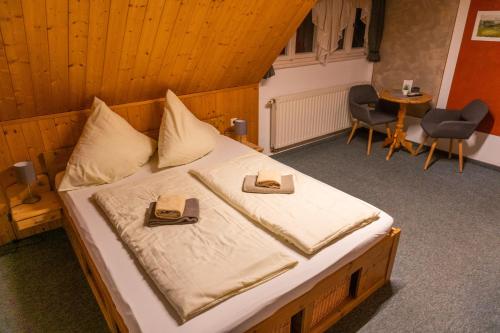 a bedroom with a bed with two slippers on it at Pension Schrammsteinbaude in Bad Schandau