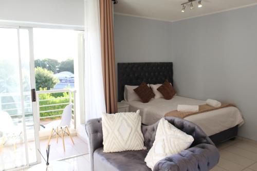 a bedroom with a bed and a couch at Abigail's Studio Apartment @ Trift Tower in Windhoek