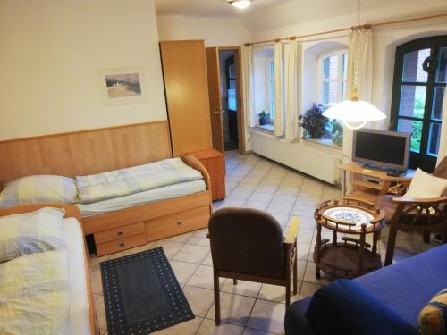 ein Schlafzimmer mit einem Bett und ein Wohnzimmer mit einem TV in der Unterkunft Hof Koopmann in Dahlem