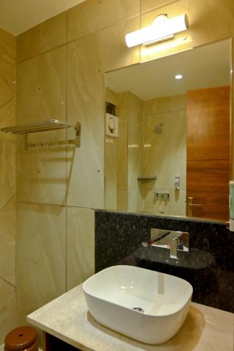a bathroom with a white sink and a mirror at MD FARMS AND RESORTS in Mathura