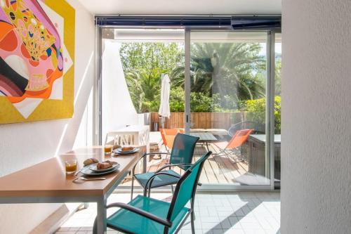 une salle à manger avec une table et des chaises dans l'établissement Le Murmure du Palmier * Mer à 2 min * Parking Privé * Terrasse, à La Grande Motte