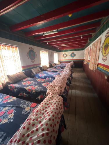 a row of beds lined up in a room at Hotel Dancing Yak in Lete