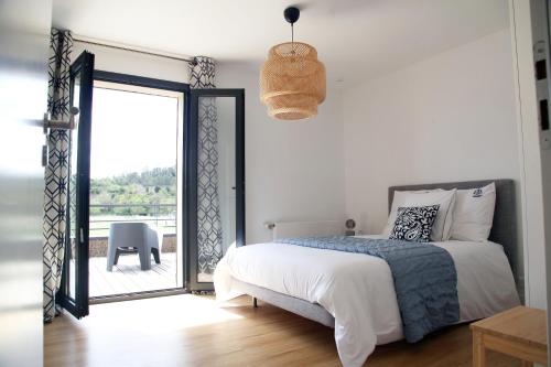 - une chambre avec un lit et une porte donnant sur un balcon dans l'établissement Lodge Marie, à Villegailhenc