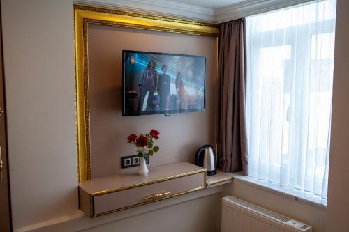 een kamer met een spiegel en een vaas met bloemen op een tafel bij Blue Zerzevan Konak Hotel in Istanbul