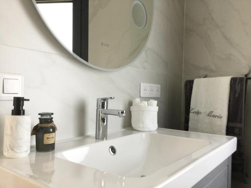 a white sink in a bathroom with a mirror at Lodge Marie in Villegailhenc