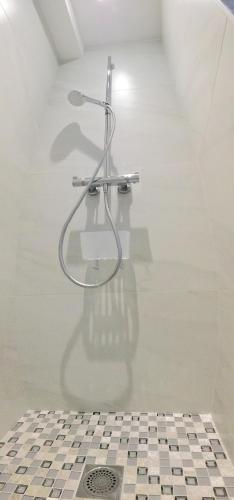 La salle de bains est pourvue d'une douche et de carrelage. dans l'établissement Lodge Marie, à Villegailhenc