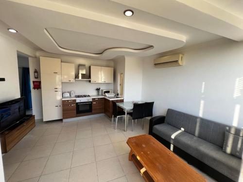 een woonkamer met een bank en een keuken bij Conmal Penthouse In Mellieha Bay in Mellieħa