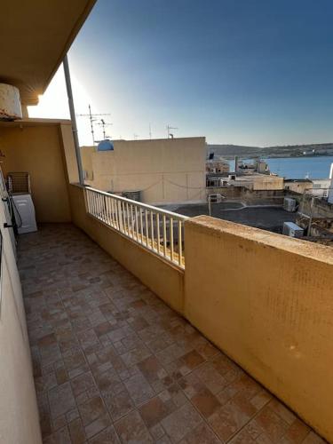 een balkon van een gebouw met uitzicht op het water bij Conmal Penthouse In Mellieha Bay in Mellieħa