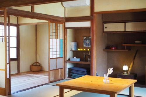 une chambre avec une table et une chambre avec des étagères dans l'établissement 岡邸, à Tonosho