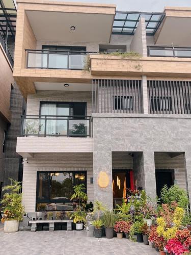a building with a lot of plants in front of it at 如沐咖啡旅宿 in Xingjian