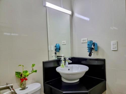 ein Badezimmer mit einem Waschbecken, einem Spiegel und einem WC in der Unterkunft One Palm Tree Villas Condo Across NAIA Terminal 3 in Manila