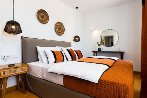 a bedroom with a bed with orange and white pillows at Mirabilia, Unique view meets true elegance in Krotiri