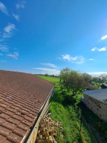 a roof of a building with a field in the background at Gite une belle Histoire in Voisey