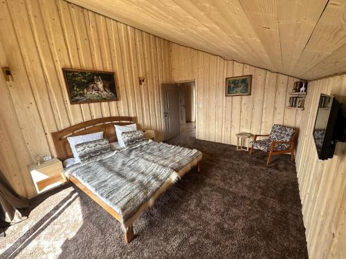 a bedroom with a bed and a chair in it at Садиба Трембіта з сауною та чаном in Rakhiv
