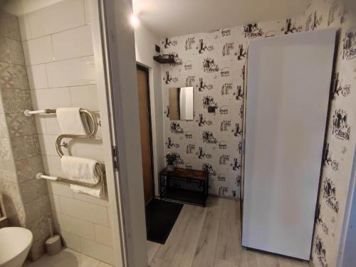 ein Bad mit schwarzen und weißen Tapeten und einem WC in der Unterkunft TROFFI T14- SELF CHECK-IN apartment for your comfort in Mažeikiai